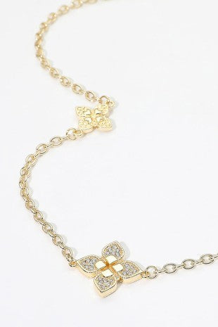 Close-up of gold-tone floral motif chain necklace with CZ accents