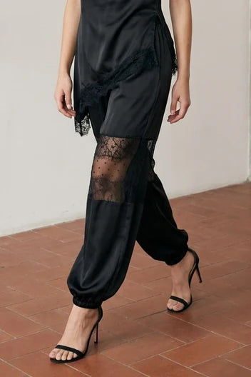 Angled view of black Satin Balloon Pants with Lace showing the balloon-leg silhouette